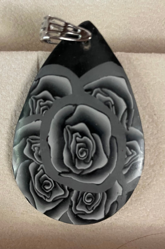 Silver roses on a black teardrop pendant